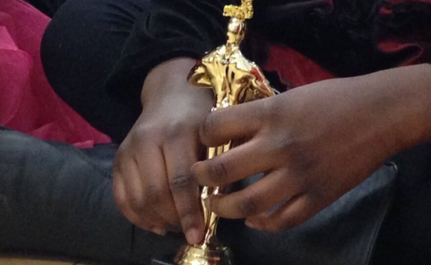 A student holds her Academy Award of Excellence statue.