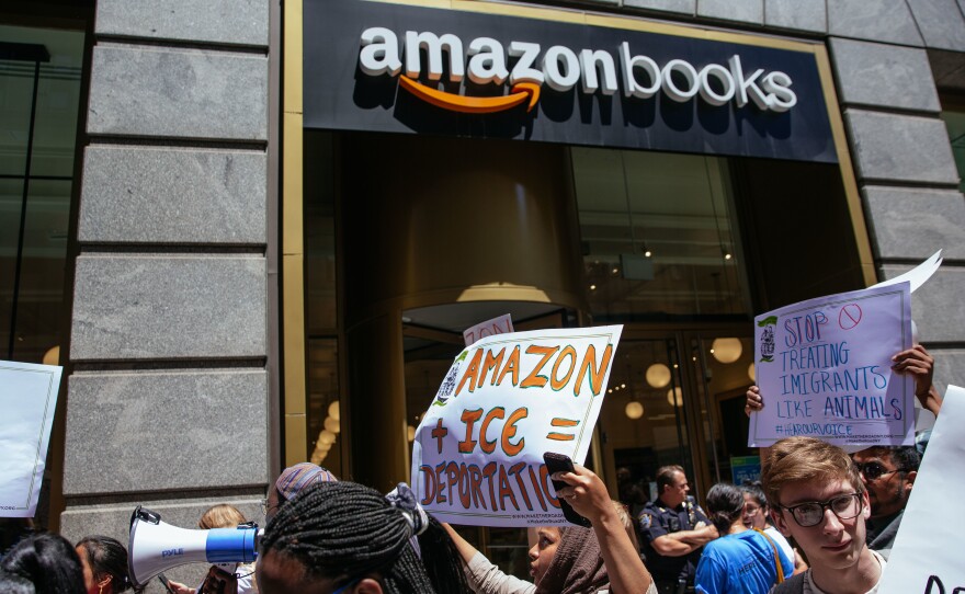 Protesters march to an Amazon store to raise awareness of Amazon's facilitation of surveillance efforts by Immigration and Customs Enforcement.