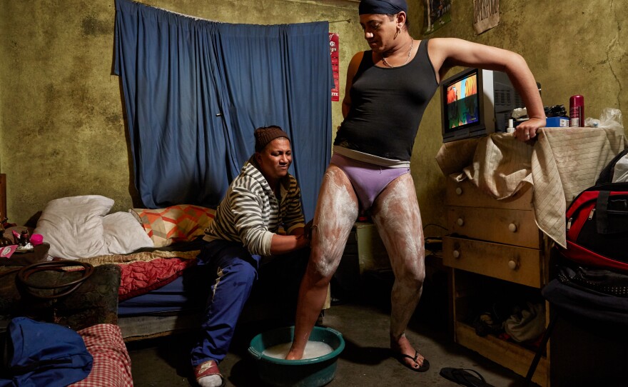 Keagan helps Chedino shave her legs the night before she needed to check into the hospital for her gender-affirming surgery in Hanover Park, Cape Town, South Africa, in 2017.