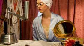Production still of a woman sitting in front of a sun lamp, from the segment "fashionable tan" segment from the film "More Than Skin Deep: Skin Cancer In America."