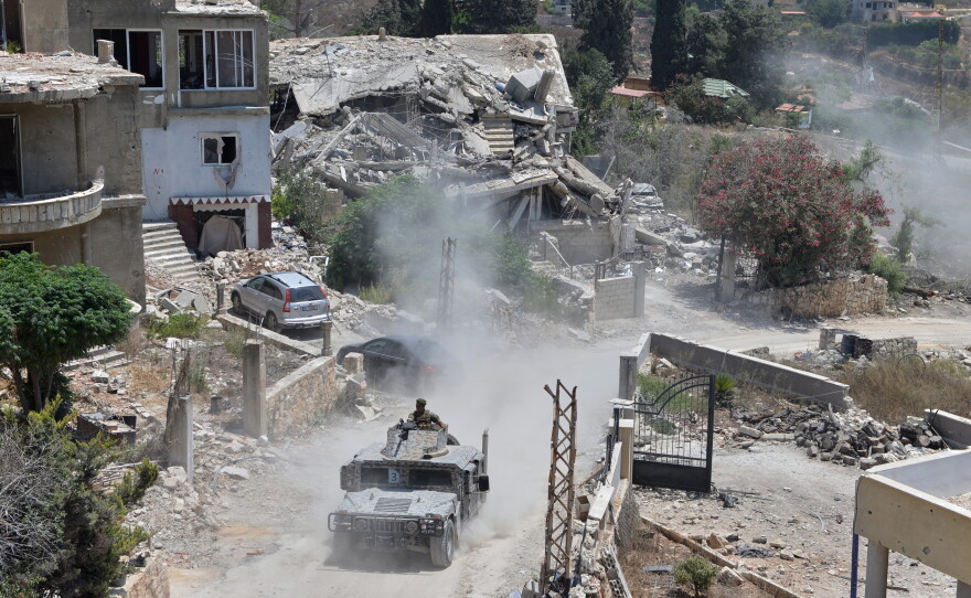 A Lebanese military vehicle drives past homes damaged during the war in the southern village of Zawtar al-Gharbieh, Lebanon, Monday, July 27, 2026.