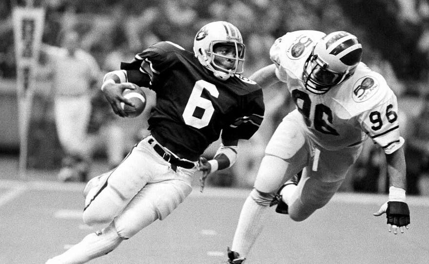 Auburn's Lionel James, (6) gains yardage as Michigan's Dave Meredith (96) tries to stop him in NCAA college football Sugar Bowl action in New Orleans, Jan. 2, 1984.
