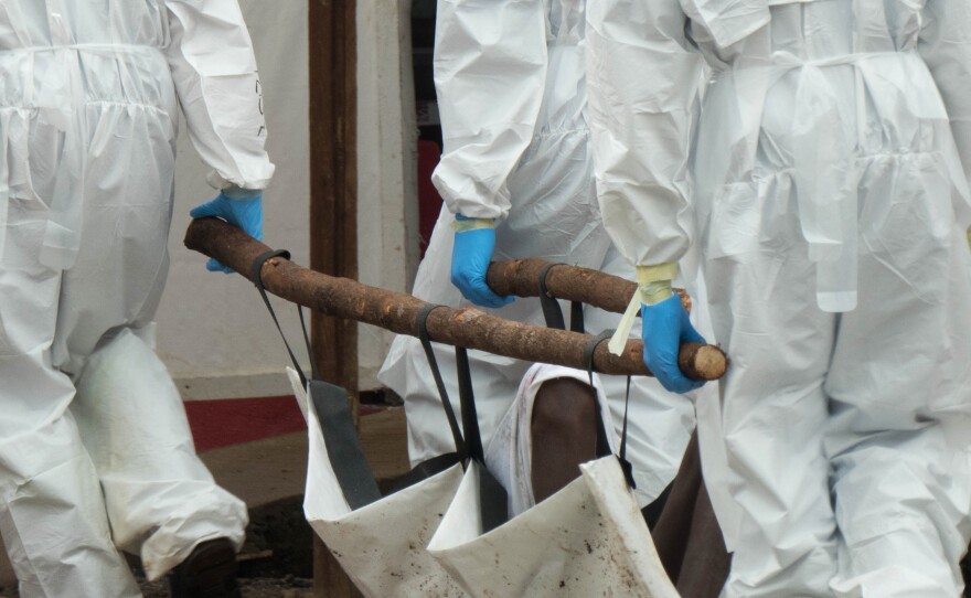 A body bag and some wooden sticks were used to fashion this stretcher.