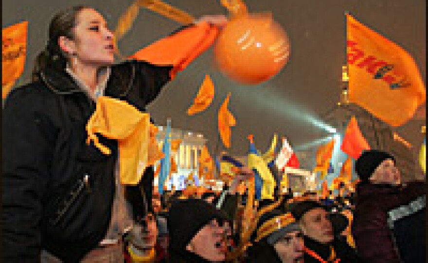 A supporter of opposition presidential candidate Viktor Yushchenko waves campaign flags and shouts slogans during a rally in central Kiev.