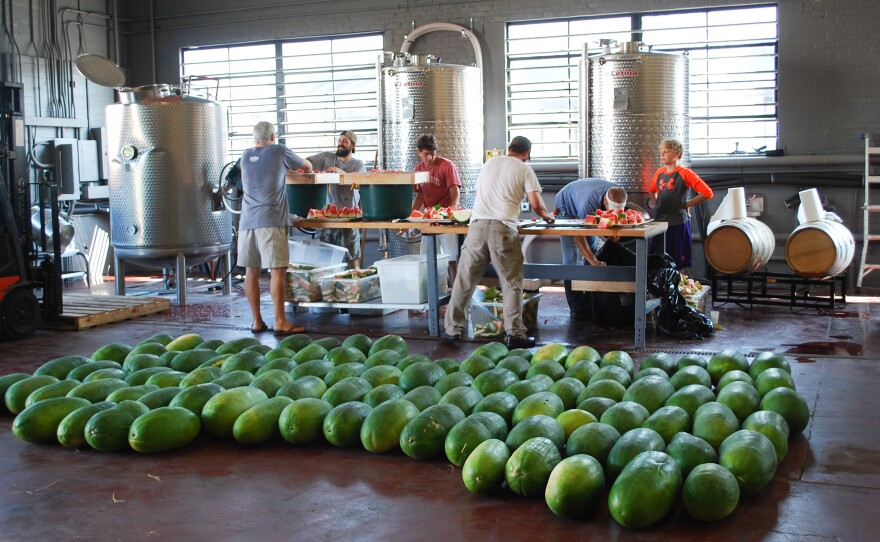 Workers at High Wire Distilling in Charleston, S.C., cut Bradford watermelons into small pieces to smash through a screen in order to extract the juice and preserve the seeds. High Wire distilled the juice into 143 bottles of heirloom brandy — 750 ml and $79 each — not made since the last century.