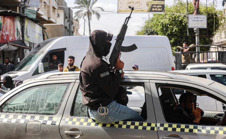 An armed and masked member of the "popular committees of protection" patrols the streets of Rafah on March 6.