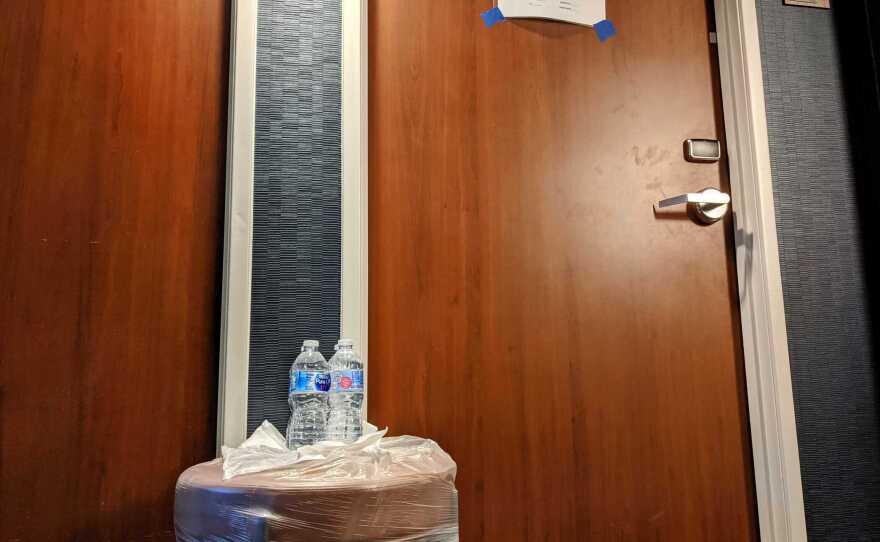Water bottles left on a stool in front of the door of Marine recruits under quarantine, Feb. 5, 2021.