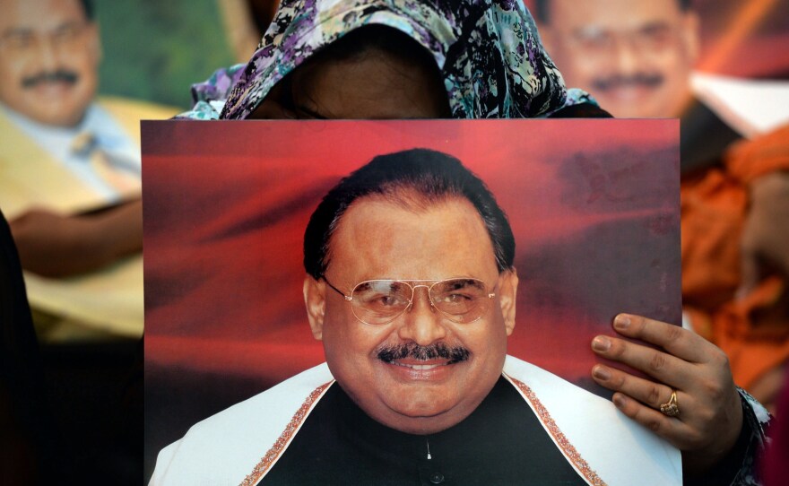 Supporters of Pakistani politician Altaf Hussain hold photographs of him, at a sit-in in Karachi. The city, home to more than 20 million, has largely ground to a halt since his arrest this week in London. Hussain is the leader of the Muttahida Quami Movement, or MQM.
