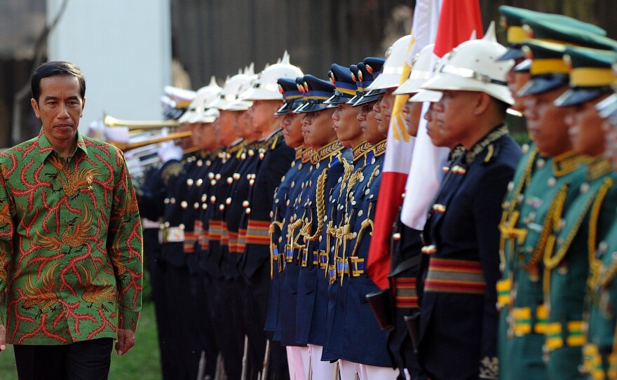 Indonesian President Joko Widodo inspects an honor guard during a visit to Manila, Philippines, on Feb. 9. Widodo's supporters see him as very different from the strongmen who have long run Indonesia. But he has dismayed some of his backers with his strong support of the death penalty.