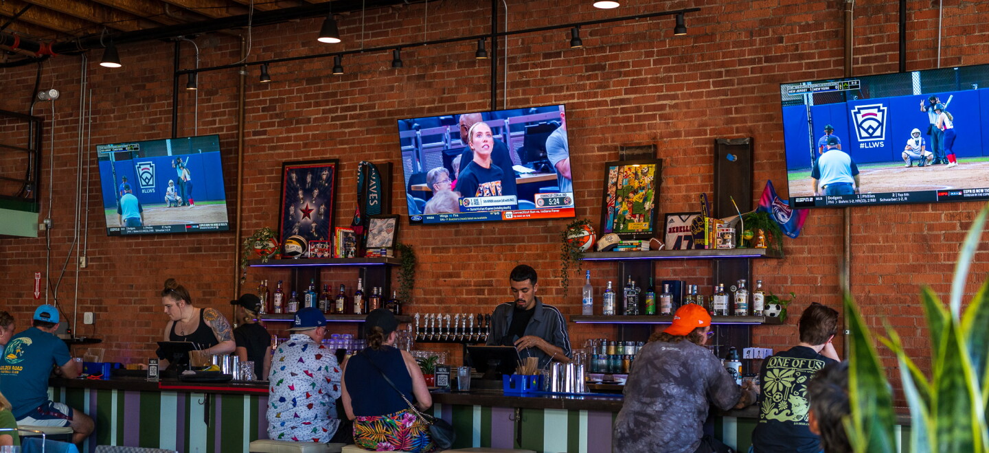 Customers sitting at the bar watch women's basketball and softball at One of Us in North Park on July 22, 2026. One of Us is San Diego's first women's sports bar.
