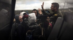 A Border Patrol agent instructs a group of people seeking asylum, including Peruvians, as they are transported for processing after crossing the border with Mexico nearby, Thursday, April 25, 2024, in Boulevard, Calif.