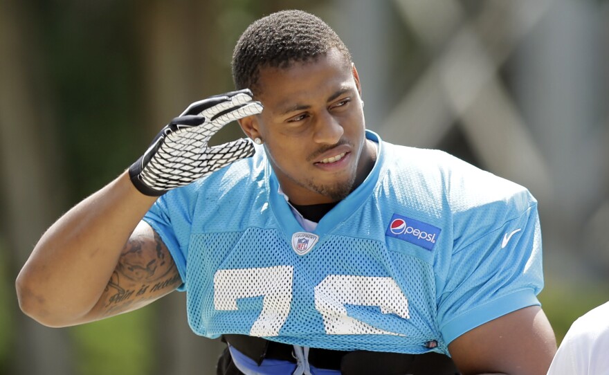 Carolina Panthers' Greg Hardy waves to fans as he arrives for an NFL football practice in Charlotte, N.C., Sept. 11, 2014.