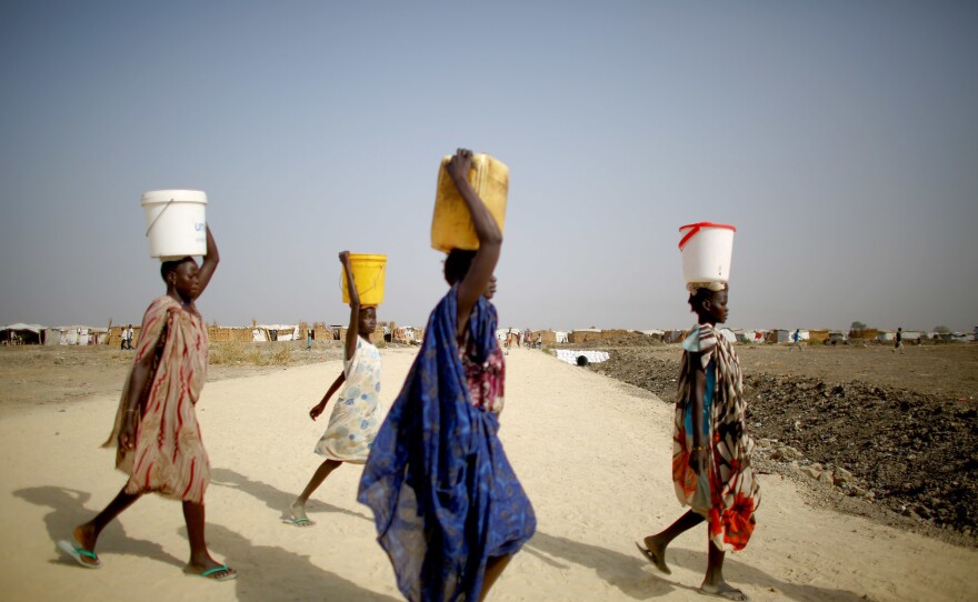 It's a daily ritual: Women carry water from communal taps back to their shelters.