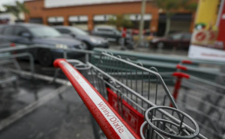 A Winn Dixie shopping cart is seen in the parking lot of the Palm Harbor, Fla., store on Wednesday, Aug. 16, 2023.