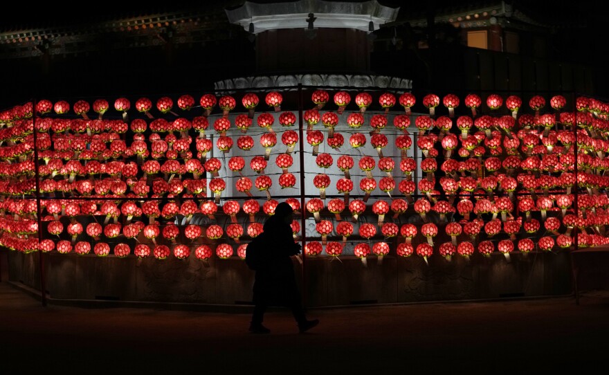 A woman prays in front of lanterns on New Year's Eve at the Jogye temple in Seoul.