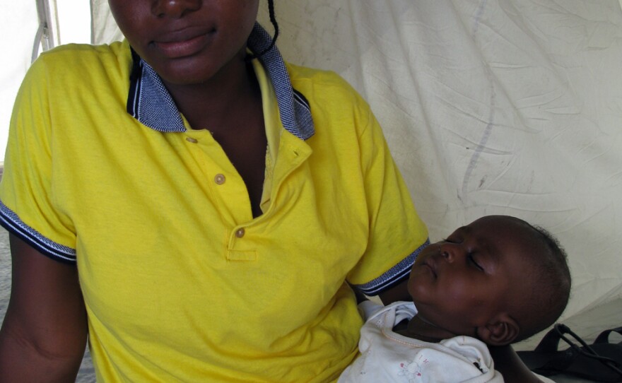 Ridlan Duvalier and her 4-month-old son sit in her tent at Camp Corail. Her boyfriend died in the quake. Because she can't leave to find work, Duvalier says, she relies on the kindness of neighbors to eat.