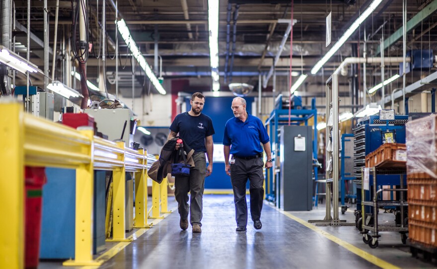 John Harris (left) walks with Warren Snead, a manager for Cooper Standard, an auto parts manufacturing factory near Spartanburg, S.C. After working as an electrician in the Air Force, Harris found the apprenticeship program at Cooper Standard, where he learns while working on the job.