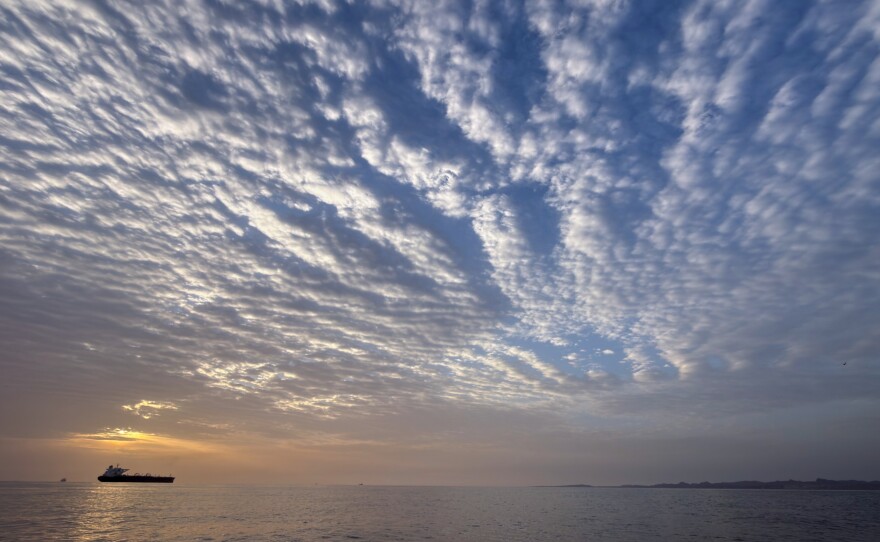 The sun rises behind a tanker anchored in the Strait of Hormuz off the coast of Qeshm Island, Iran, Saturday, April 18, 2026.