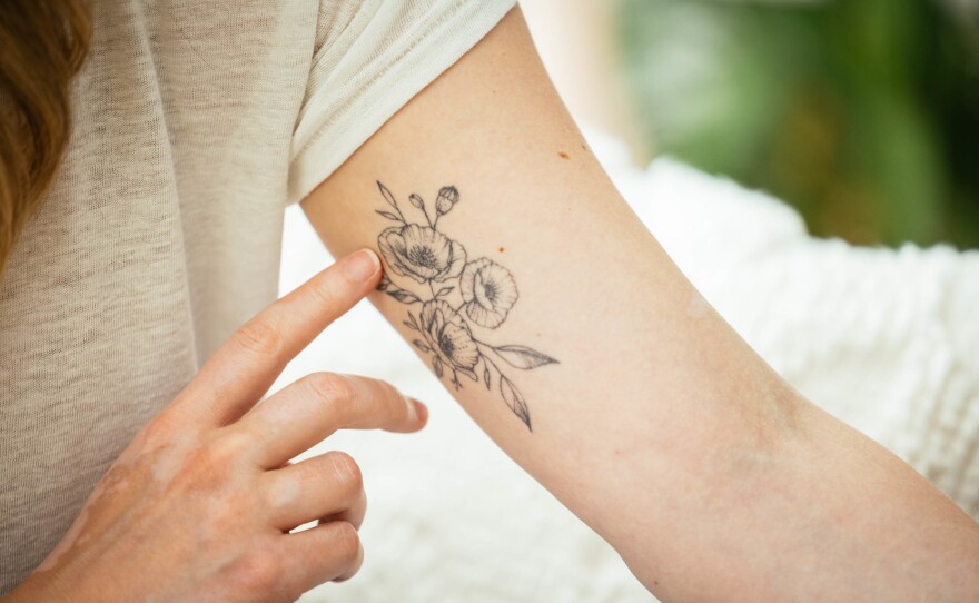 Stickler displays the poppy tattoo she got to commemorate her time on Broadway as an understudy for Elphaba in <em>Wicked</em>. After taking a coding boot camp, Stickler now works as a software engineer.