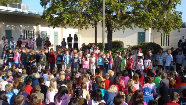 Elementary students from a San Diego Unified school attend an assembly in the school's courtyard.