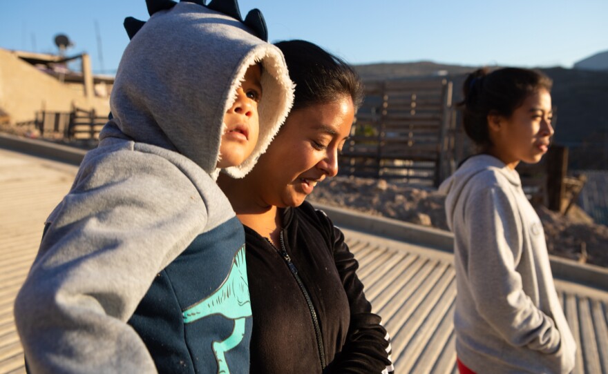 Mairani Rubillo Padilla, her son Tadeo and Hazel Lucia Flores Rodriguez walk to the store outside of the Libélula women’s shelter in Tijuana, Dec. 9, 2022.