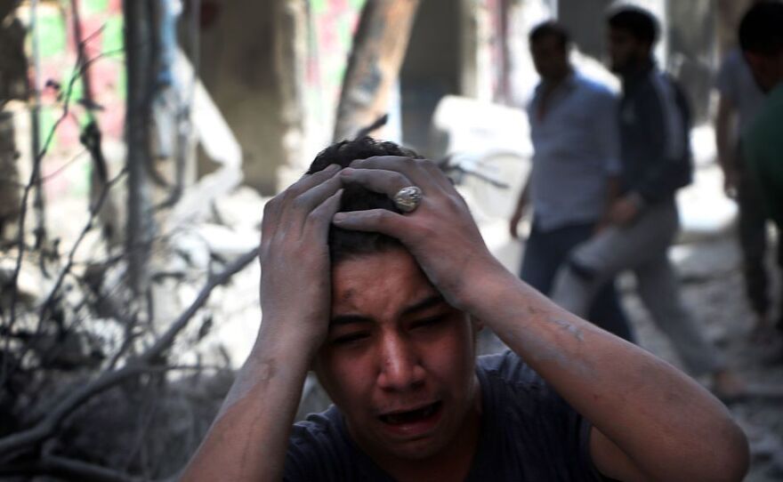 Syrian civilians are seen in the aftermath of renewed attacks on an opposition-controlled area in Aleppo on Tuesday.