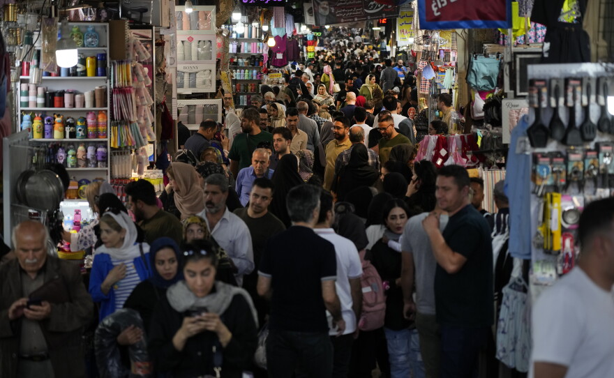 People walk through the old main bazaar of Tehran, Iran, on a Saturday night, Oct. 19, 2024.
