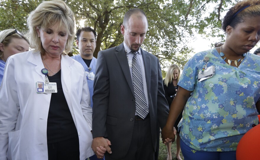 Hospital workers attend a prayer vigil outside Texas Health Presbyterian Hospital, on Tuesday.