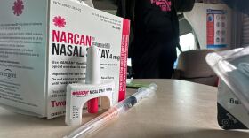 Nasal (left) and injected (middle) doses of naloxone sit on a table inside of a recreational vehicle used by the San Diego Harm Reduction Coalition.