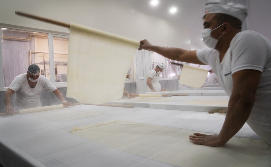 Pastry is rolled on a marble surface while making baklava at Imam Cagdas.