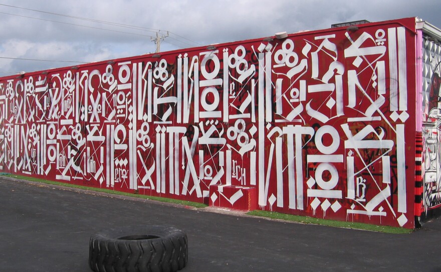 Los Angeles artist RETNA developed his own alphabet from gang writing and calligraphy. The top line on this RETNA mural reads "sacred dance of memories."