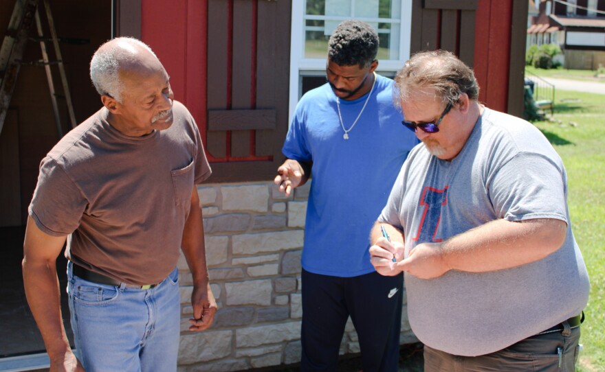 University of Illinois Extension director Jody Johnson (right) exchanges contact information with Lee Wright (left) and son Roman Wright. The extension's office in southern Illinois has launched a vaccination education program that aims to reach this storied city; Johnson knows listening to locals will be key.