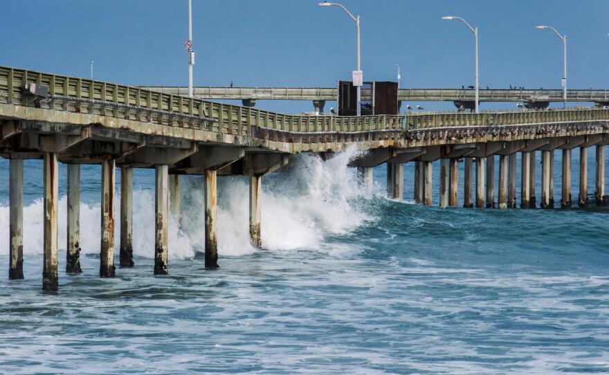 Waves crash under the Ocean Beach Pier on June 10, 2026.