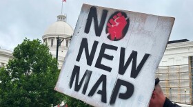A demonstrator holds up a sign outside the Alabama Statehouse in Montgomery on Thursday.
