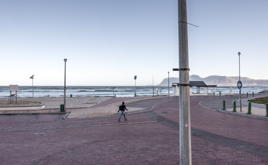 A man walks along the empty seafront at Muizenberg, Cape Town, South Africa, on day three of the country's coronavirus lockdown.