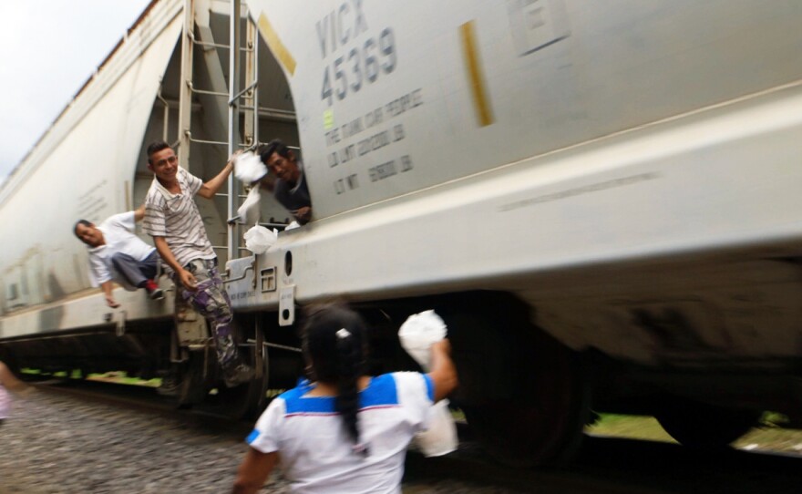Volunteers such as this woman — who's with a group that calls itself "Las Patronas" — throws bags of food and water to migrants in Veracruz, Mexico, who are headed toward the U.S.-Mexico border.