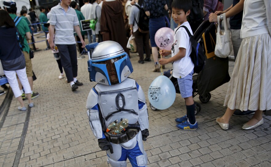 A celebrant dressed up as Jango Fett walks at a Star Wars Day fan event in Tokyo Monday.