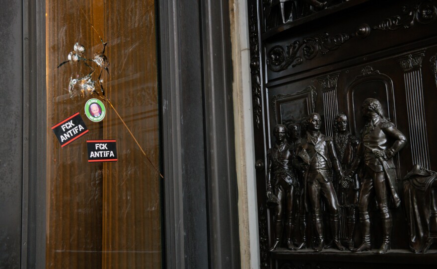 Stickers reading "Fck Antifa" are stuck on a broken window at the U.S. Capitol after the building was breached by rioters on Jan. 6.