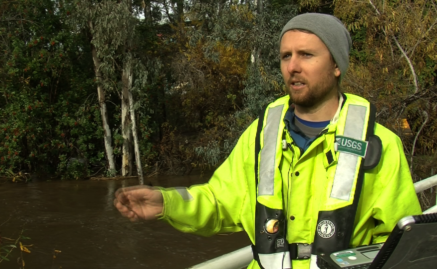 Zach Barry, a USGS hydrological technician collects river data at a flood alert station near Fashion Valley, Jan. 7, 2016.