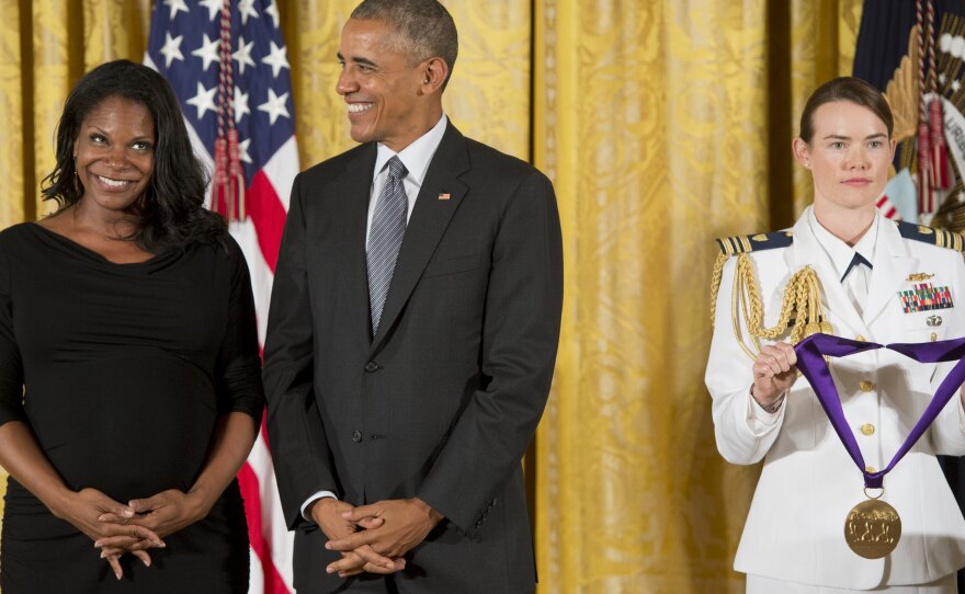 President Obama laughs as he presents actress and singer Audra McDonald with the 2015 National Medal of Arts.