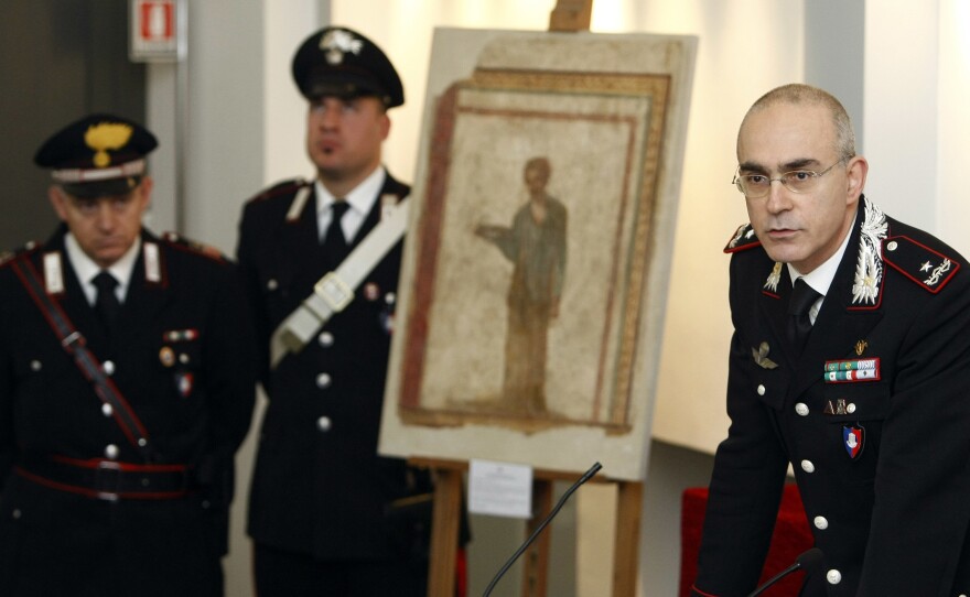 Italian Carabinieri paramilitary police general Giovanni Nistri (right) discusses the recovery and seizure of nearly 60,000 pieces of looted or stolen artwork and archaeological artifacts at a press conference in January 2010. Beside him is one of those pieces, a plaster wall painting dating back some 2,000 years.