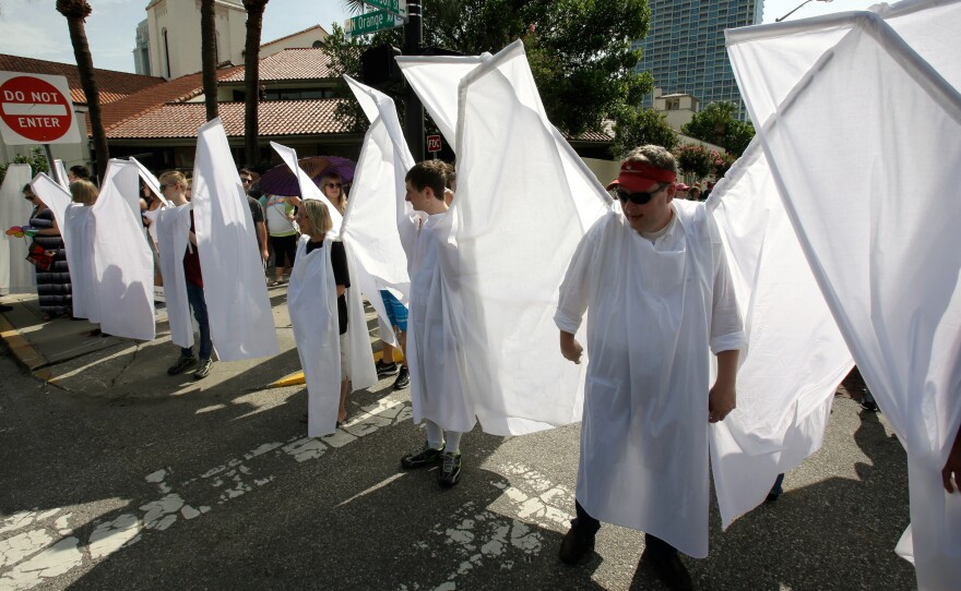 Counter demonstrators dressed as angels to show support and solidarity block the view of protesters near the funeral service for Christopher Andrew Leinonen, one of the victims of the Pulse nightclub mass shooting, outside the Cathedral Church of St. Luke on Saturday in Orlando, Fla.
