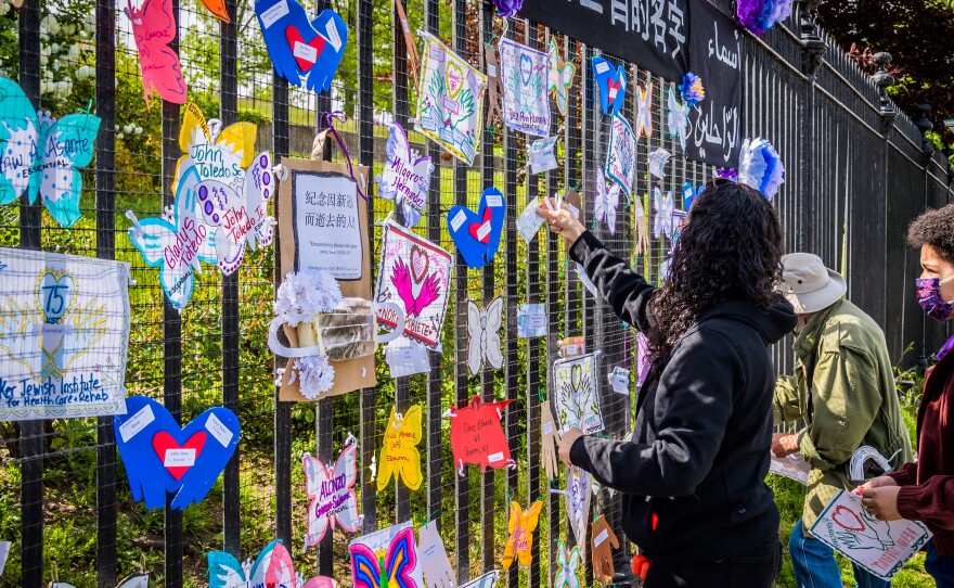 A volunteer artist sets up a memorial May 20 in Brooklyn. Artists and volunteer organizers across New York City put up memorials throughout the five boroughs to honor those who died of COVID-19.