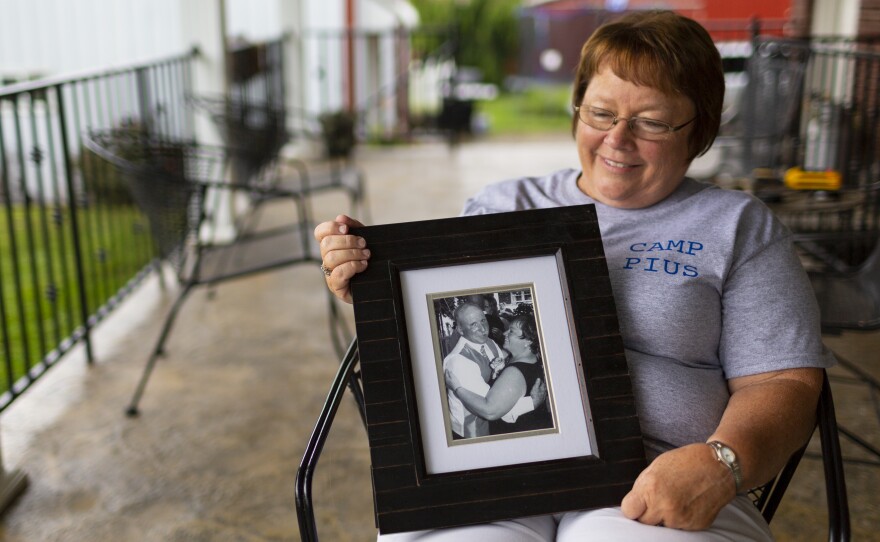 Lisa Hobbs holds a picture of her husband, Gene "Pius" Hobbs. Hobbs was raking gravel with the Meade County public works crew when a dump truck backed over and killed him.