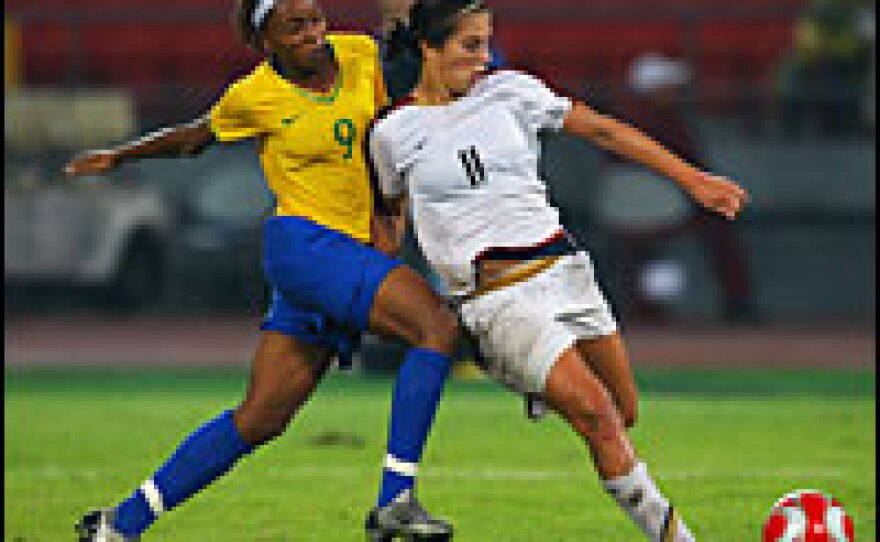 American Carli Lloyd (right) holds off the challenge from Ester of Brazil  during the women's gold medal match Thursday.