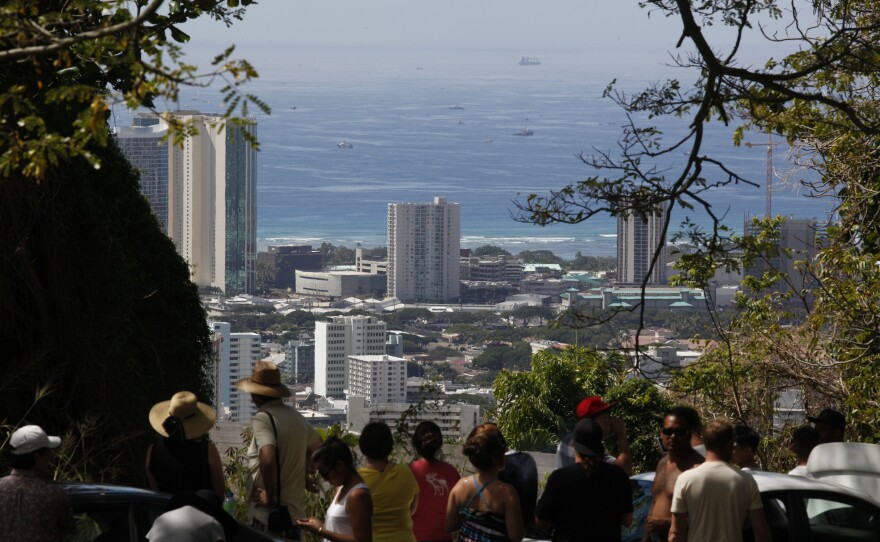 A crowd of people watch Oahu's southern shore in anticipation of a possible tsunami along Tantalus Drive in Honolulu, Hawaii on February 27, 2010 in Honolulu, Hawaii. 