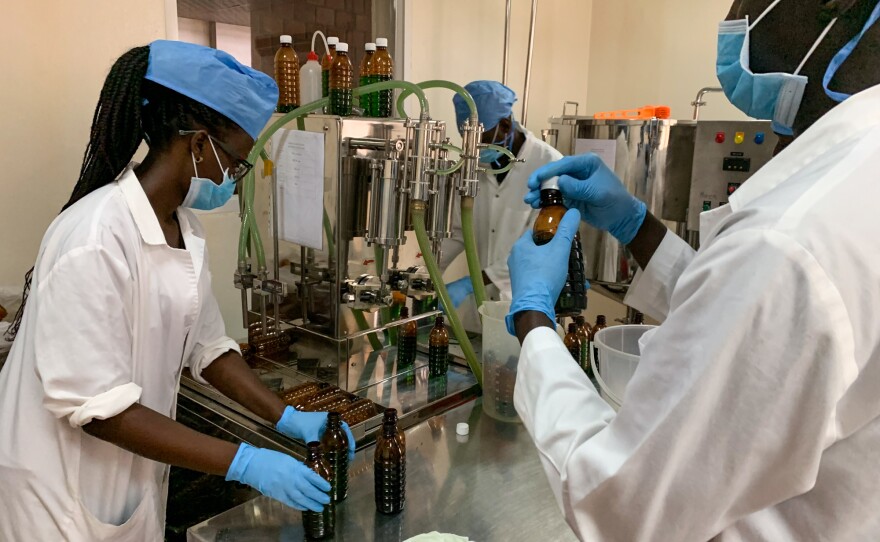 Workers at a government-sponsored facility in Kampala bottle liquid morphine. The solution essentially consists of morphine powder mixed with water. Uganda provides it to patients for free.
