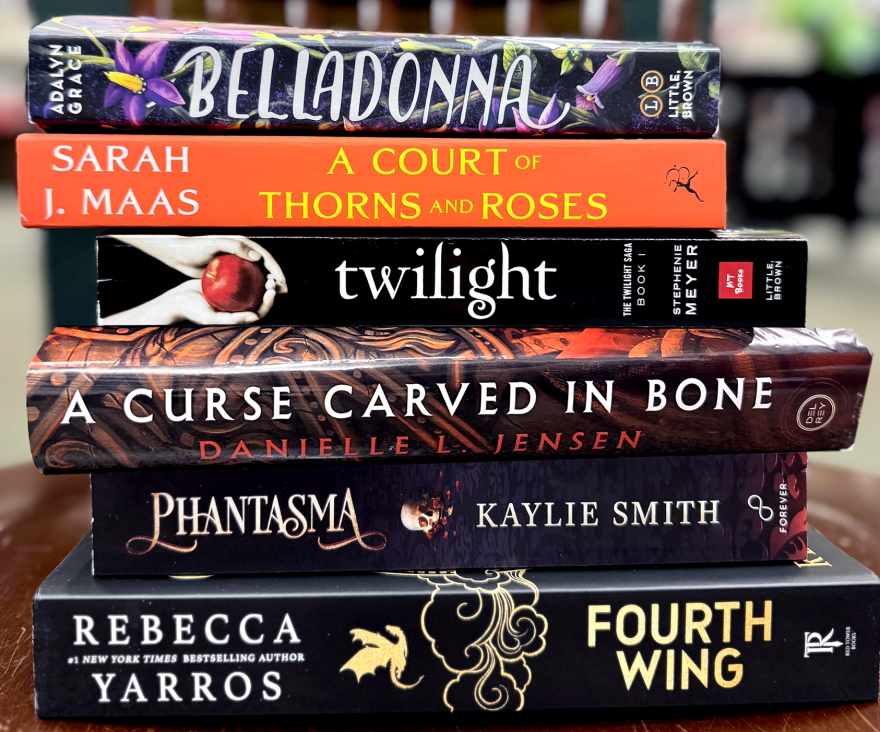 A stack of romantasy books — "Belladonna" by Adalyn Grace, "A Court of Thorns and Roses" by Sarah J. Maas, "Twilight" by Stephenie Meyer, "A Curse Carved in Bone" by Danielle L. Jensen, "Phantasma" by Kaylie Smith and "Fourth Wing" by Rebecca Yarros — is pictured Monday, July 28, 2025.