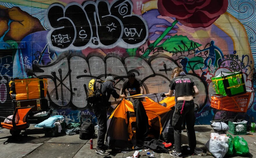 Michael Johnson takes down his tent in downtown San Francisco with the help of activists on Aug. 9, 2024.