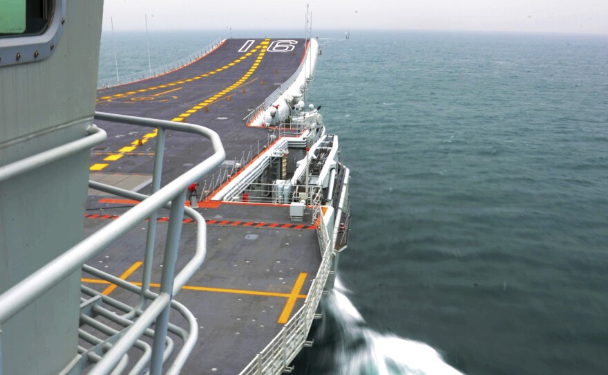 China's first aircraft carrier, Liaoning, cruises towards a military base in Sanya, Hainan province, in an undated picture made available in November.